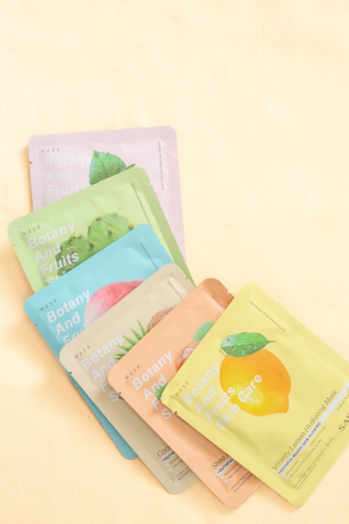 Colorful botanical sheet masks for skincare on pastel background.